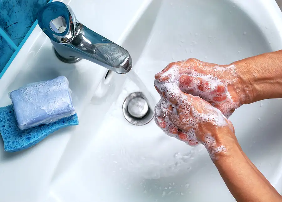 young adult washing their hands thoroughly in bathroom sink - Springfield, IL